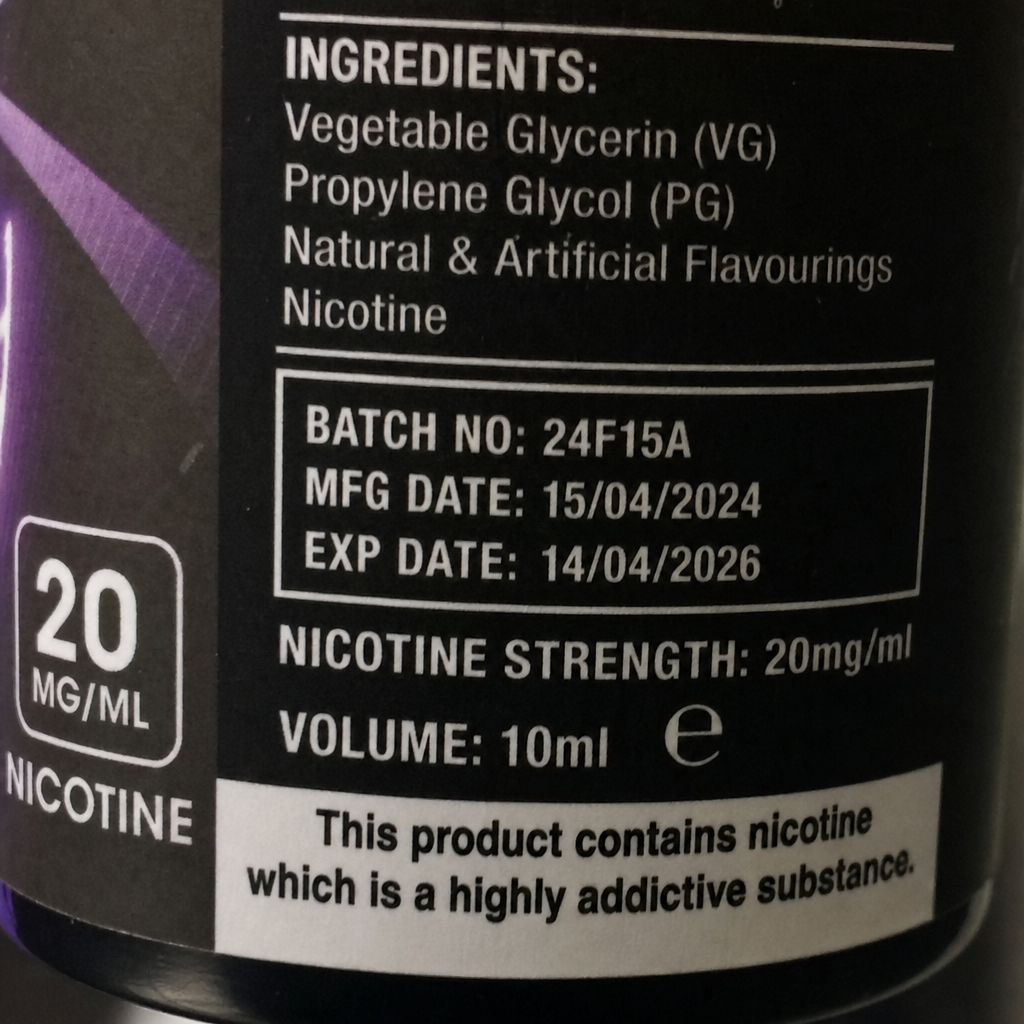 Close-up of e-liquid bottle label displaying ingredients VG PG, 20mg per ml nicotine strength, batch number, manufacturing date, and expiration details - mushroom disposable vape review by VapeFeat