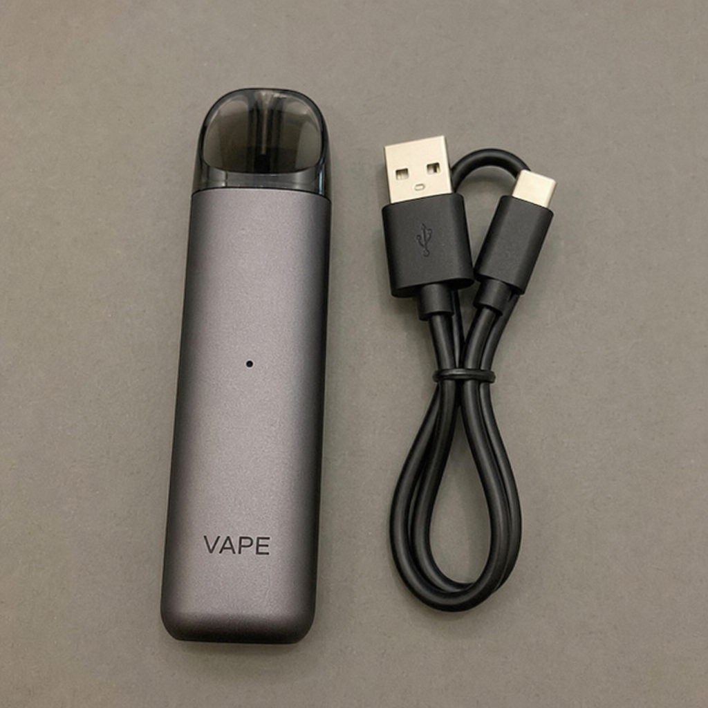 Sleek matte grey refillable pod vape kit resting beside its included USB-C fast charging cable - Pod Vape Starter Kits and Maintenance guide on VapeFeat